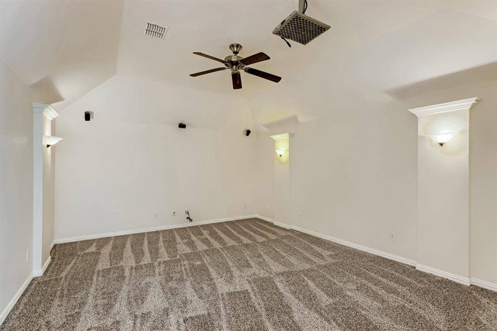 7013 Salem Court, Rowlett, TX 75089 Vaulted ceilings featuring recessed wall niches, integrated wall sconces, carpeted flooring, and a ceiling fan