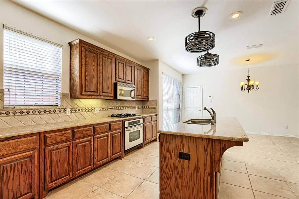 7013 Salem Court, Rowlett, TX 75089 Kitchen featuring wood cabinetry, stone-finish countertops, ceramic tile flooring, a built-in gas cooktop, and decorative tile backsplash