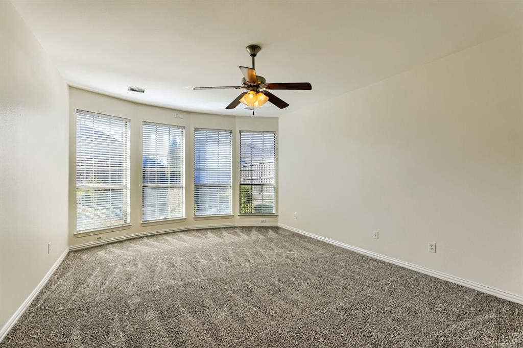 7013 Salem Court, Rowlett, TX 75089 Wall-to-wall carpeting, four large windows, and a ceiling fan with integrated lighting