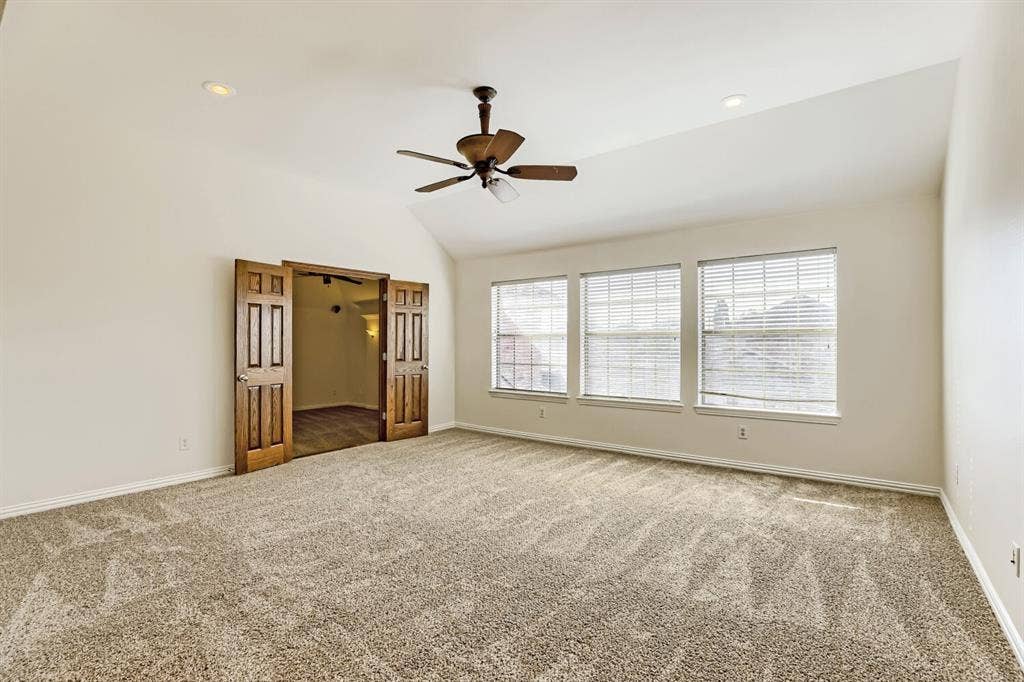 7013 Salem Court, Rowlett, TX 75089 Vaulted ceiling with a centrally mounted ceiling fan, neutral carpeting, three paneled windows, and recessed lighting