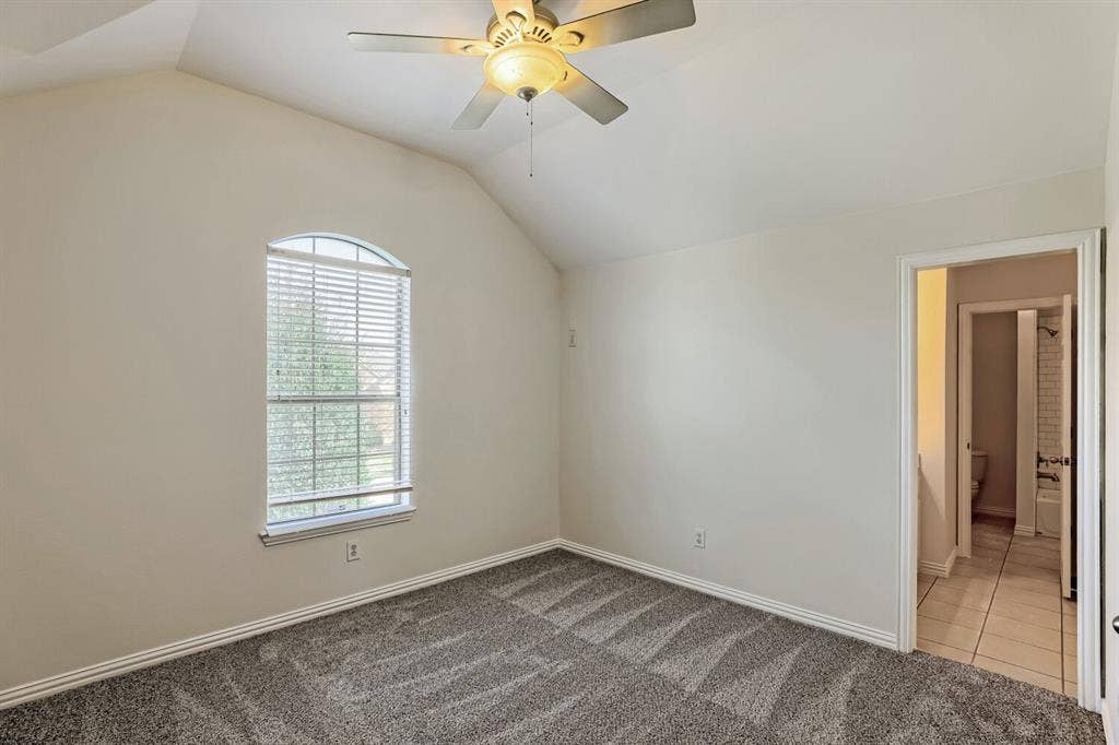 7013 Salem Court, Rowlett, TX 75089 Vaulted ceilings, carpeted flooring, arched window, and overhead ceiling fan with integrated lighting