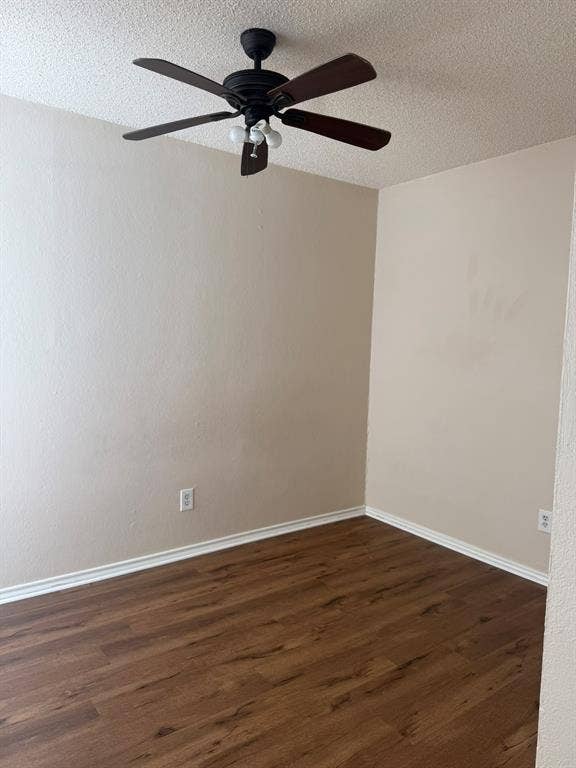 Room featuring wood-finish flooring, textured ceiling, and a dark-toned ceiling fan with integrated lighting