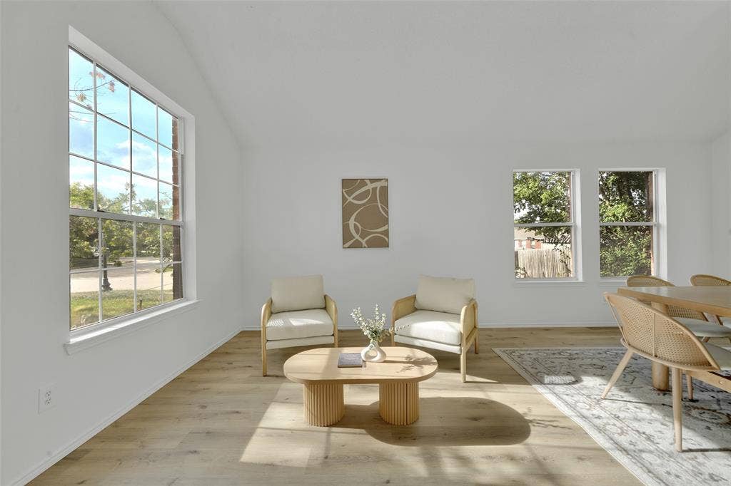 Vaulted ceilings, wood-finish flooring, and multiple grid-pattern windows