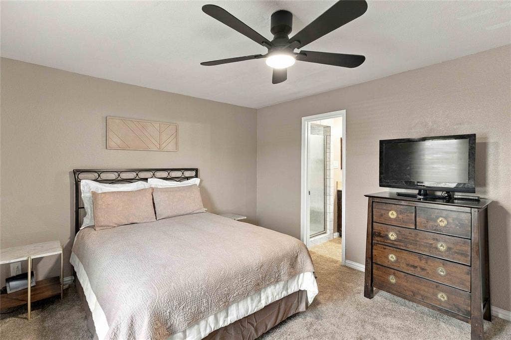 18240 Midway Road, #1706, Dallas, TX 75287 Neutral wall-toned room featuring a central five-blade matte black ceiling fan with an integrated light fixture and neutral carpeting