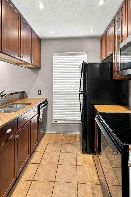 18240 Midway Road, #1706, Dallas, TX 75287 Kitchen featuring wood cabinetry, stone-finish countertops, ceramic tile flooring, built-in stainless steel appliances, and recessed ceiling lighting
