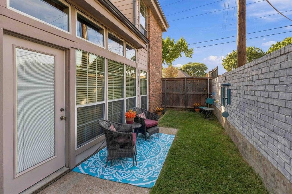 18240 Midway Road, #1706, Dallas, TX 75287 Exterior space featuring a concrete patio, a private lawn, a wood fence, and a painted brick privacy wall