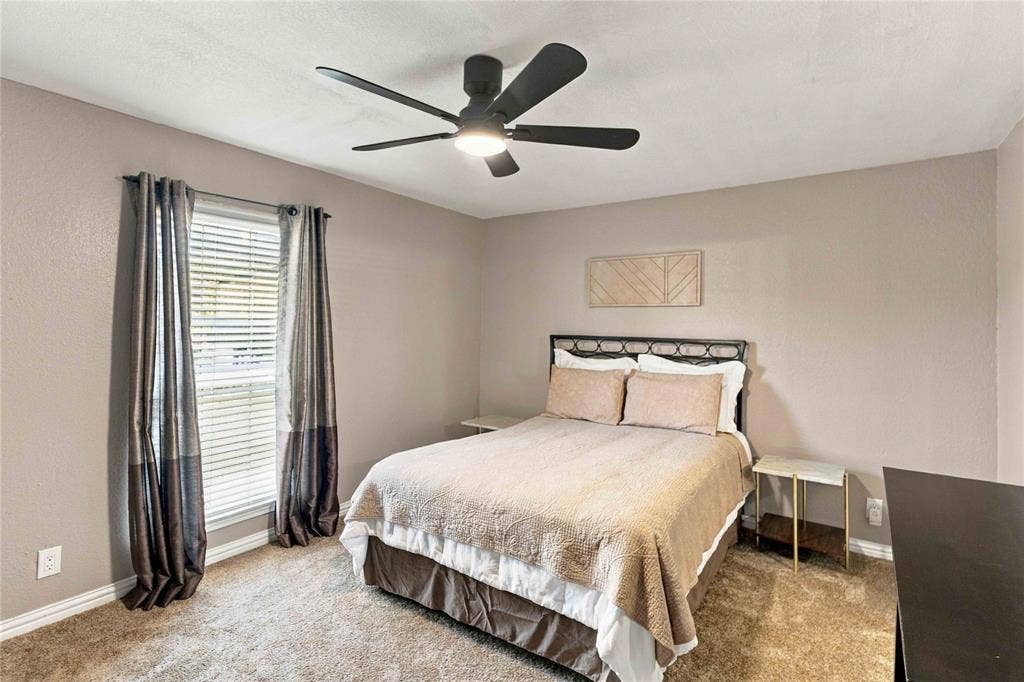 18240 Midway Road, #1706, Dallas, TX 75287 Neutral-toned interior space featuring wall-to-wall carpeting and a matte black five-blade ceiling fan with integrated lighting