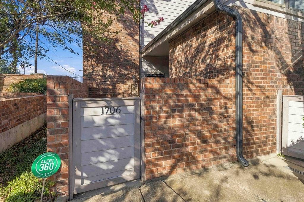 18240 Midway Road, #1706, Dallas, TX 75287 Exterior facade featuring a brick masonry finish, a private gated entrance, and horizontal paneling detail