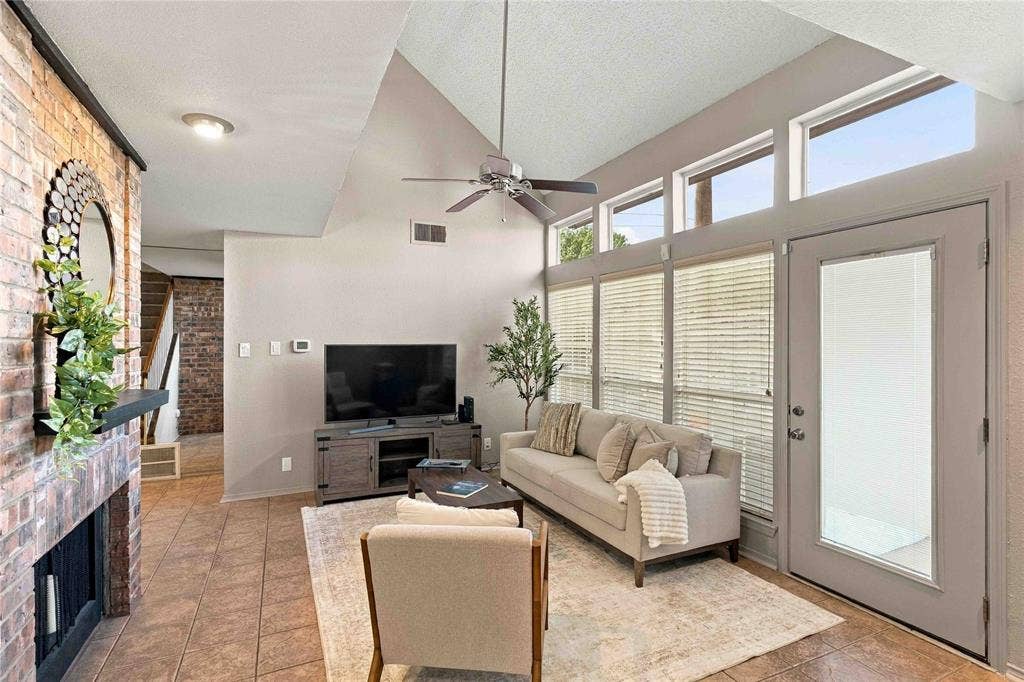 18240 Midway Road, #1706, Dallas, TX 75287 Vaulted ceilings, floor-to-ceiling brick fireplace with wood-finish mantle, ceramic tile flooring, and oversized windows with transom accents