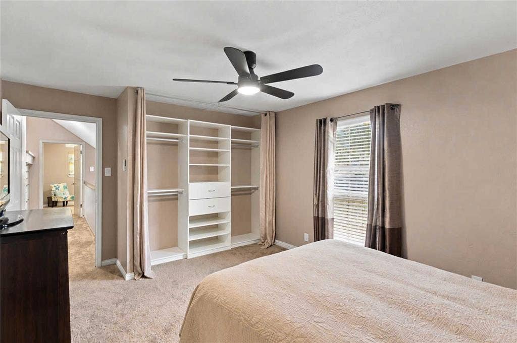 18240 Midway Road, #1706, Dallas, TX 75287 Room featuring a built-in closet system with integrated shelving and drawers, a ceiling fan with integrated lighting, wall-to-wall carpeting, and a window with blinds