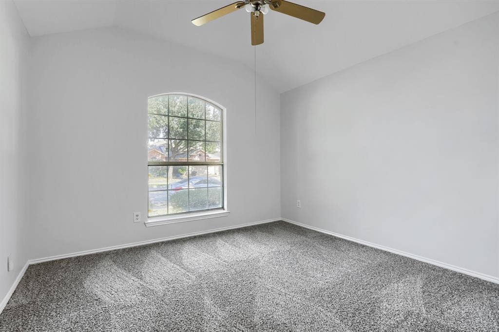 Neutral interior featuring carpeting, a ceiling fan, and dual-door closet storage