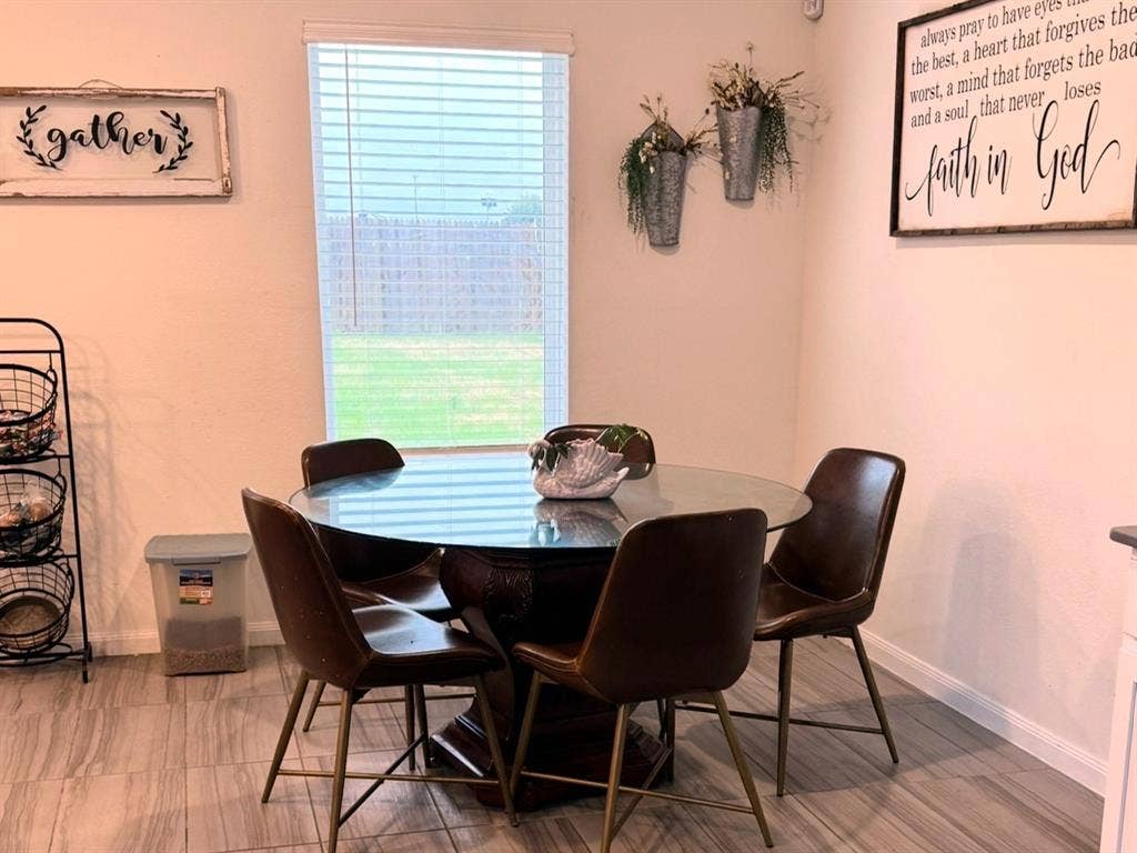 Ceramic tile flooring and a central window with horizontal blinds