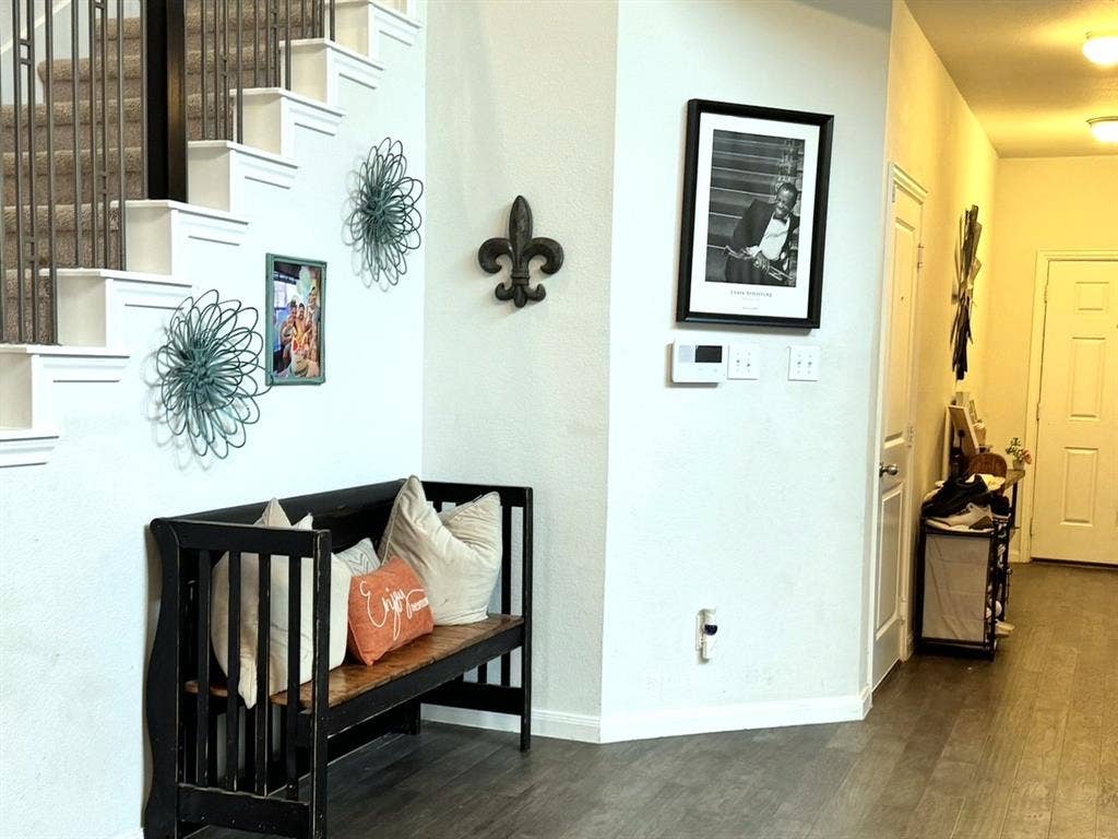 Entryway featuring wood-finish flooring, a staircase with metal balusters, and recessed ceiling lighting