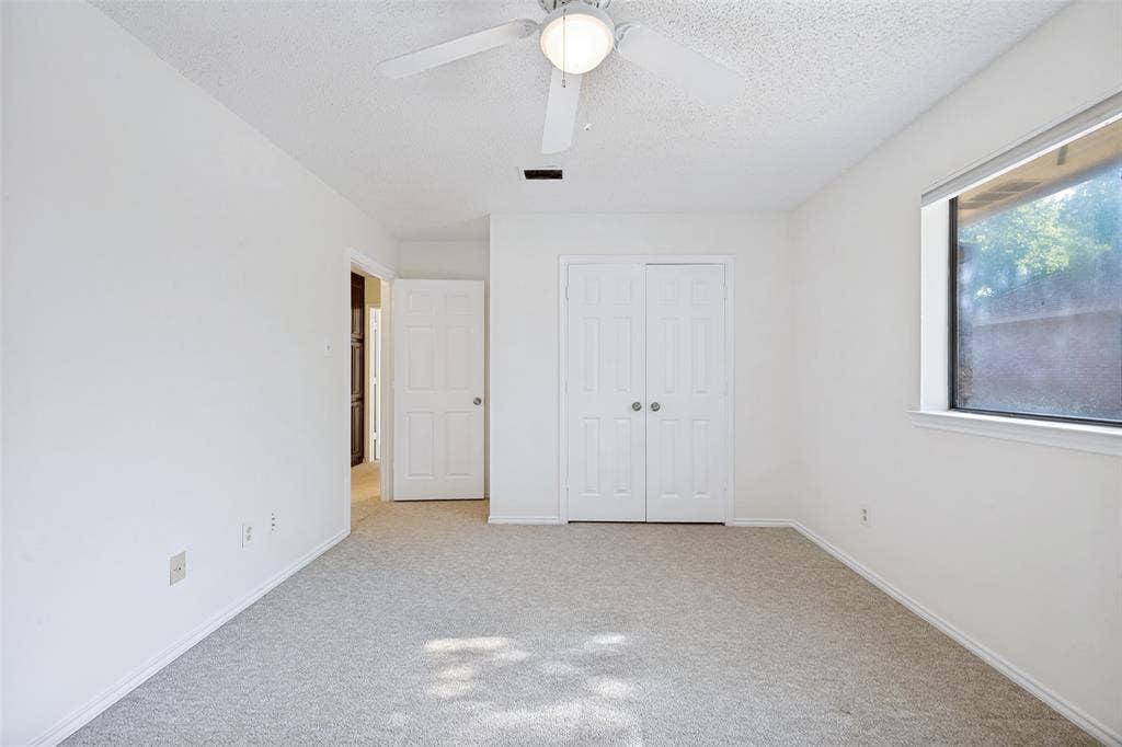 6627 Sawmill Road, Dallas, TX 75252 Neutral interior featuring wall-to-wall carpeting, white interior doors, double-door closet, and a ceiling-mounted light fixture with fan