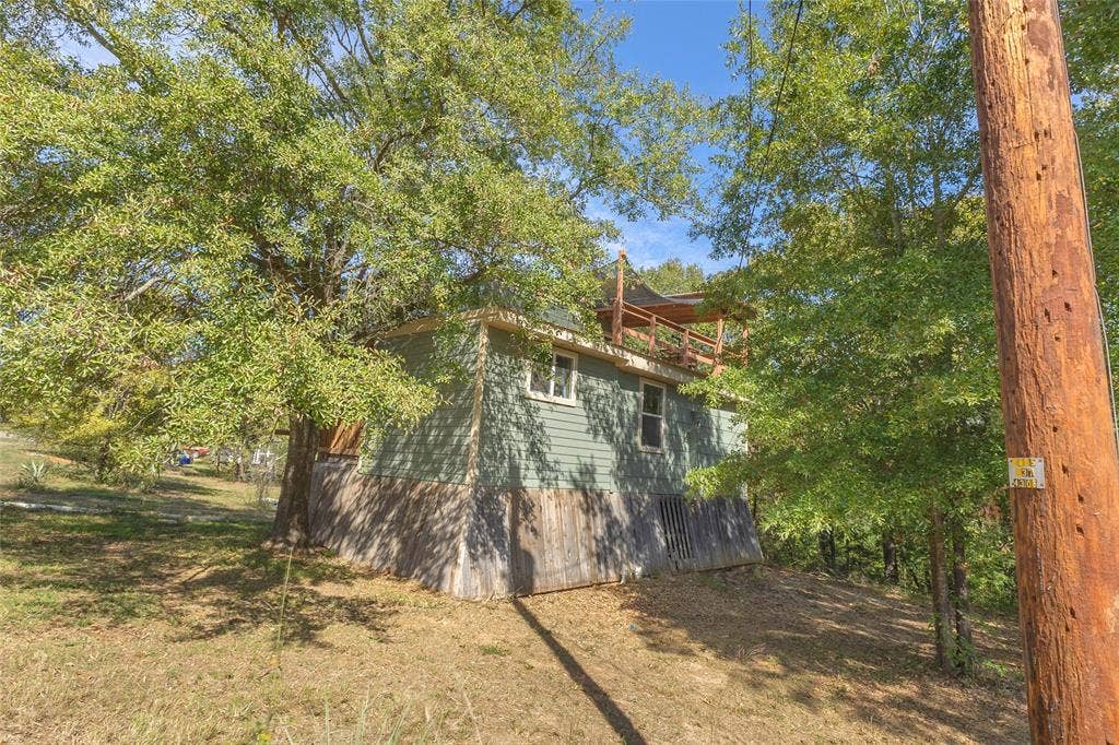 131 Baff Bay Drive, Gun Barrel City, TX 75156 Exterior view of home set among mature trees