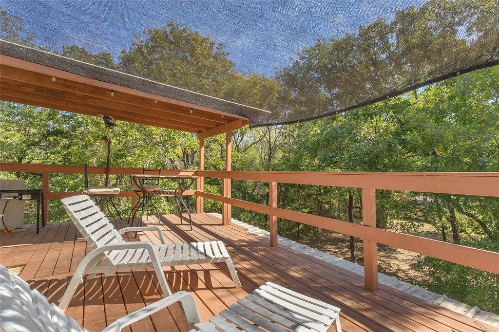 131 Baff Bay Drive, Gun Barrel City, TX 75156 Upper wood deck with covered area, shade sail, and tree views