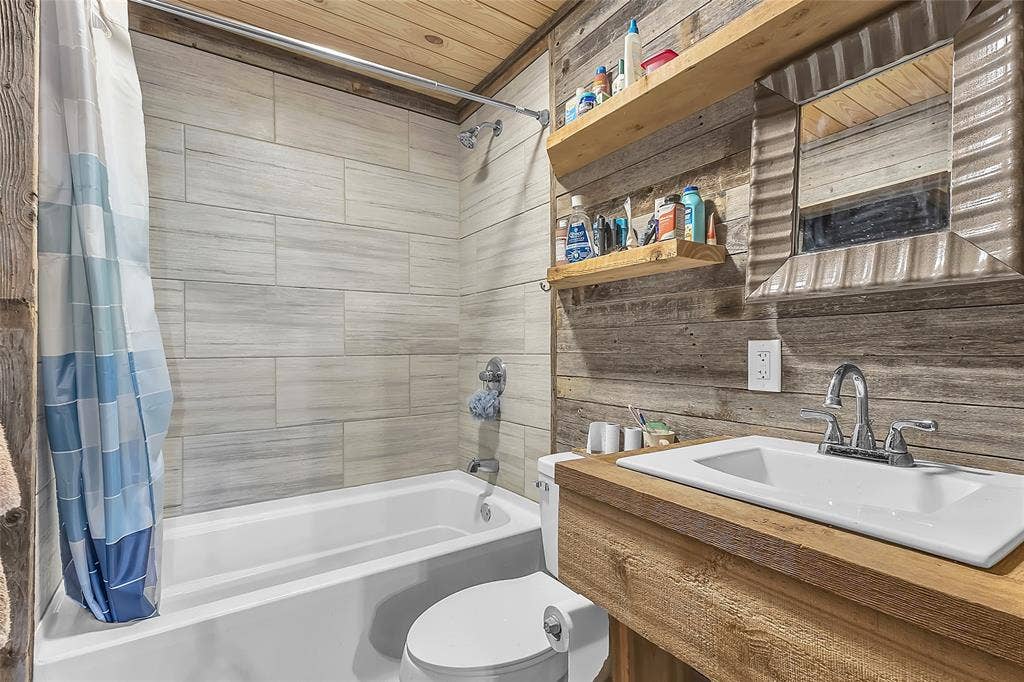 131 Baff Bay Drive, Gun Barrel City, TX 75156 Bathroom with tub-shower, wood-plank walls, and wood vanity