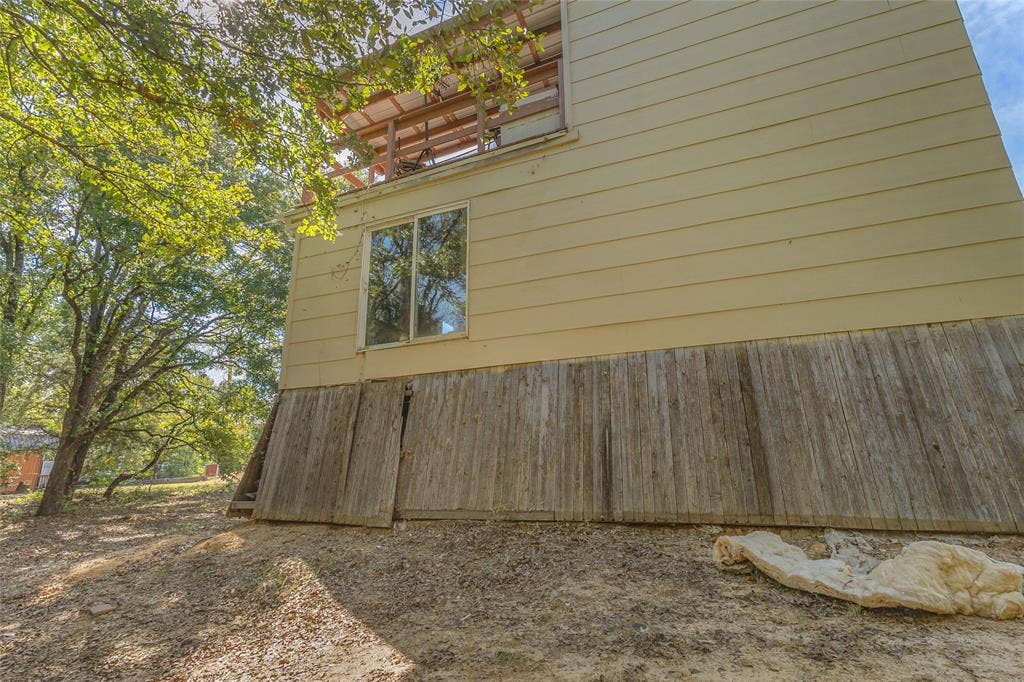 131 Baff Bay Drive, Gun Barrel City, TX 75156 Exterior side with windows and upper deck above