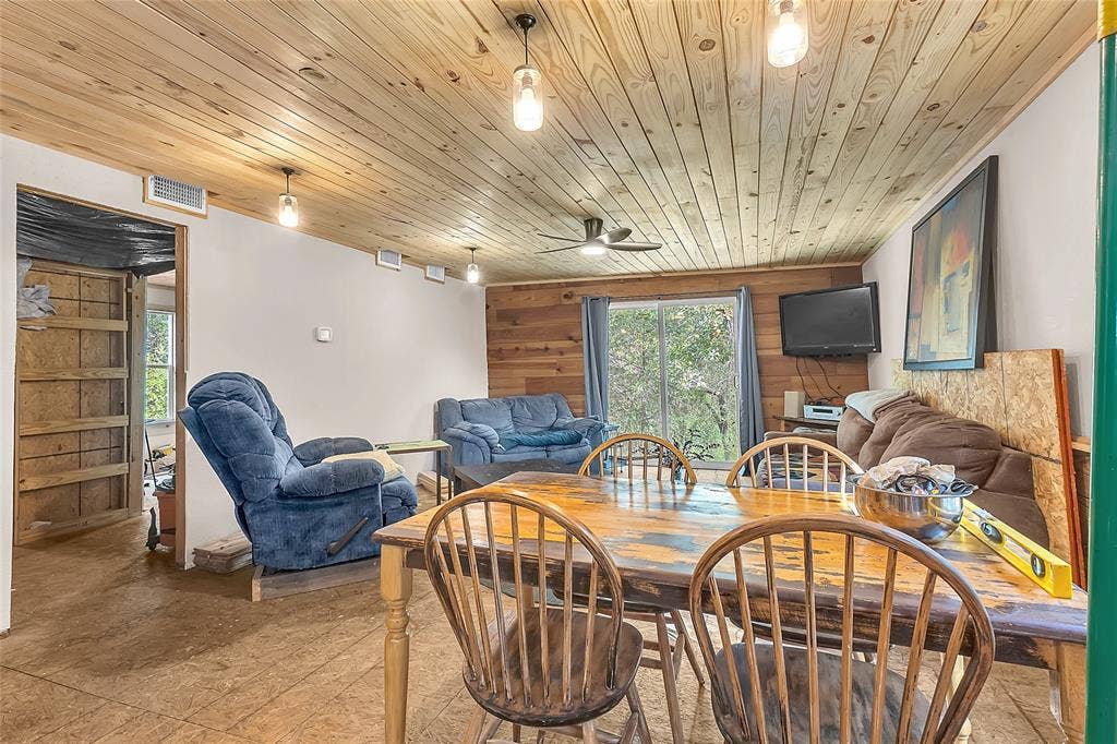 131 Baff Bay Drive, Gun Barrel City, TX 75156 Dining and living space with wood accent wall and sliding glass door
