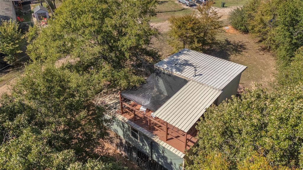 131 Baff Bay Drive, Gun Barrel City, TX 75156 Overhead view of metal roof and covered upper deck among trees