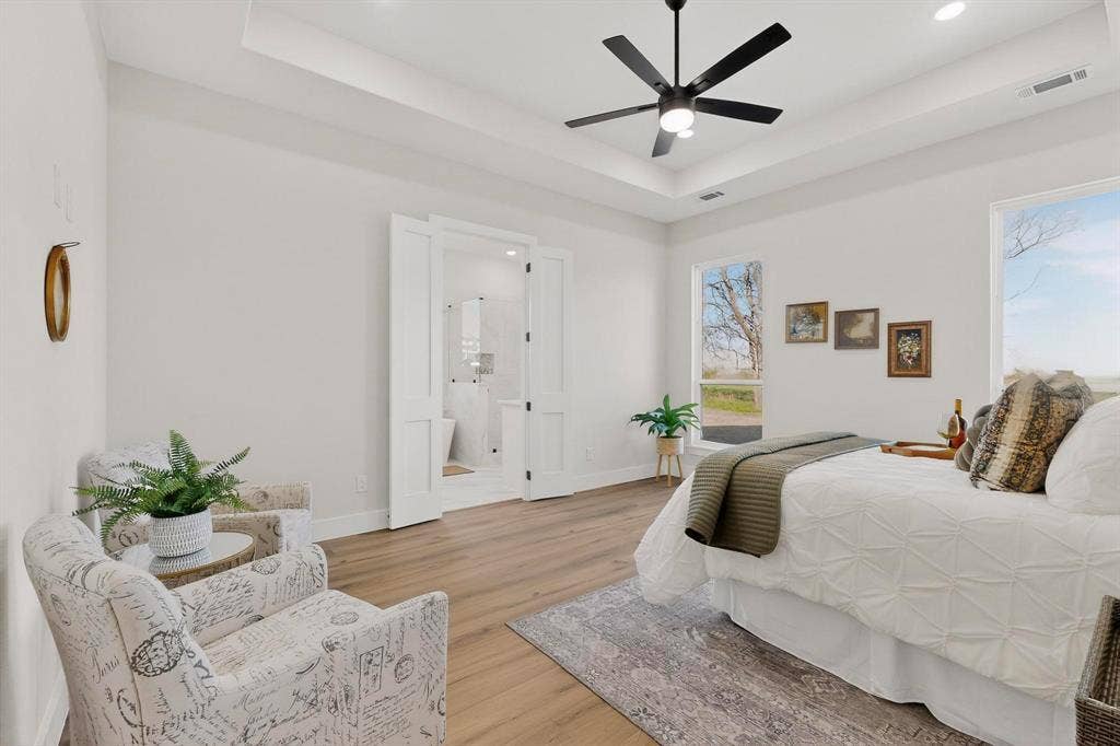Tray ceiling, wood-finish flooring, recessed lighting, and a modern ceiling fan