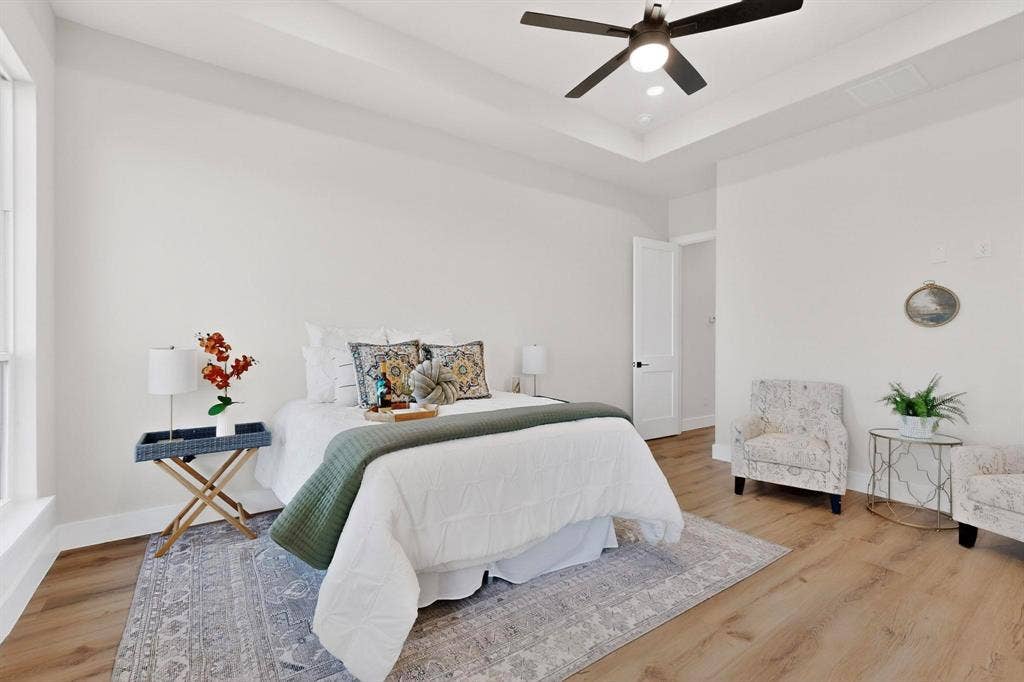 Tray ceiling with recessed lighting, wood-finish flooring, and a central ceiling fan
