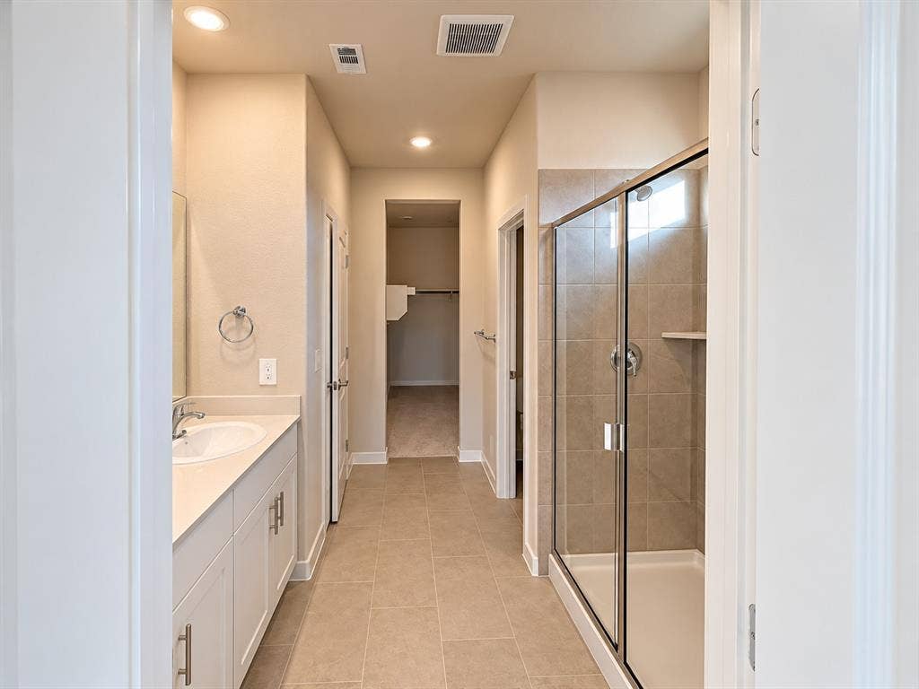 Double vanity with white cabinetry, solid-surface countertop, and dual oval undermount sinks