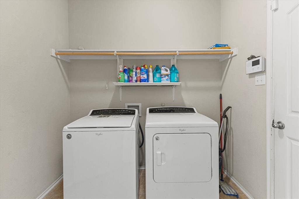 Laundry area featuring built-in white shelving with a hanging rod and neutral-toned wall paint