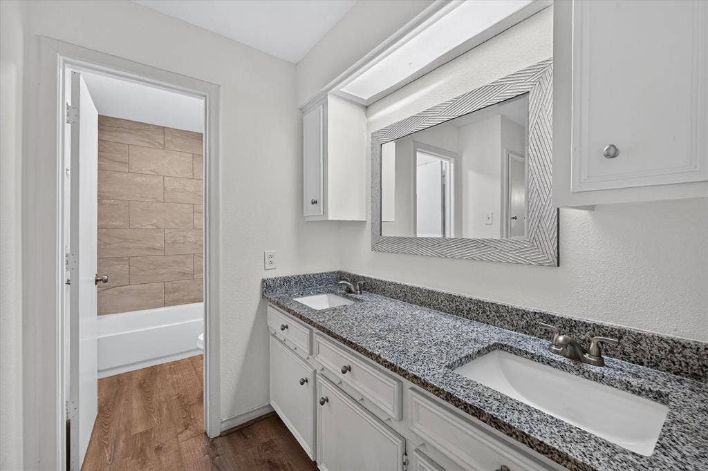Dual-vanity cabinet with stone-finish countertop, undermount sinks, and integrated lighting