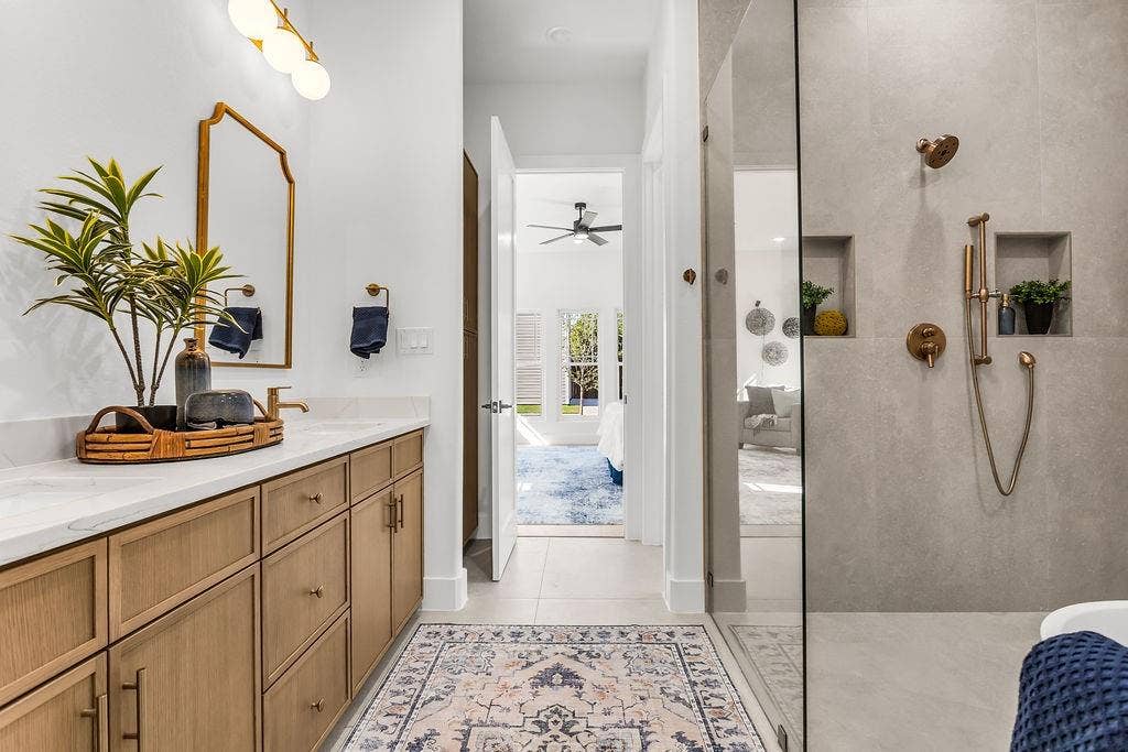 4631 Junius Street, Dallas, TX 75246 Spa-caliber primary bath with freestanding soaking tub, frameless walk-in shower, fluted tile accent wall, and Delta Trinsic brushed gold fixtures