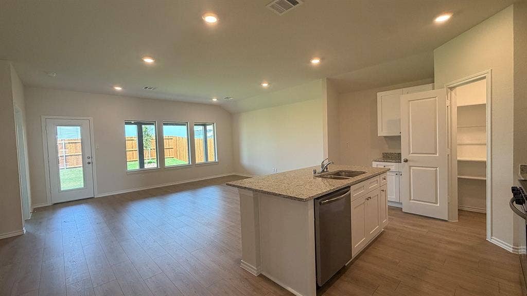 Open-concept living area featuring wood-finish flooring, recessed lighting, and multiple windows