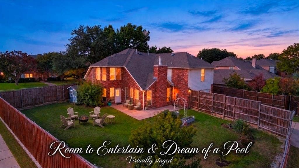 Two-story brick exterior featuring a multi-pitched roof, masonry chimney, concrete patio, and fenced backyard