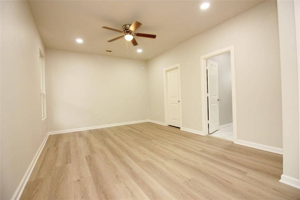 Neutral interior featuring wood-finish flooring, recessed lighting, and a central ceiling fan