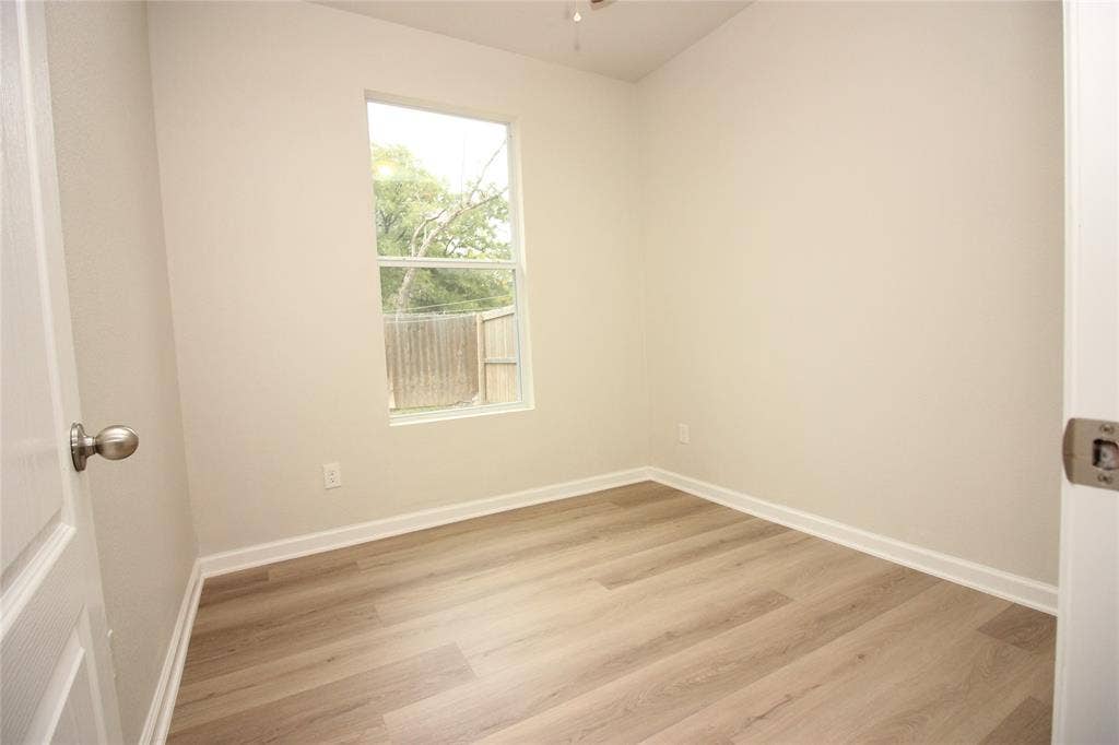 Neutral interior space featuring wood-finish flooring, light-toned walls, and a single-hung window with exterior exposure