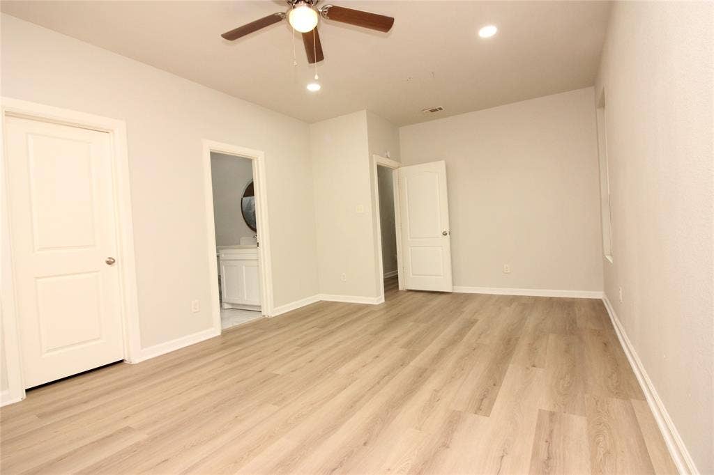 Interior space featuring wood-finish flooring, recessed lighting, a ceiling fan with integrated lighting, and multi-panel doors