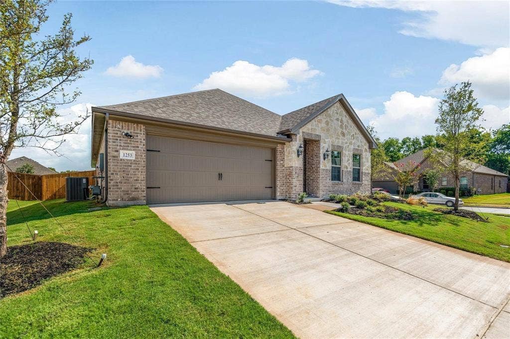 1253 Carinna Drive, Anna, TX 75409 Exterior facade featuring a combination of brick and stone masonry, a multi-car attached garage, and a concrete driveway