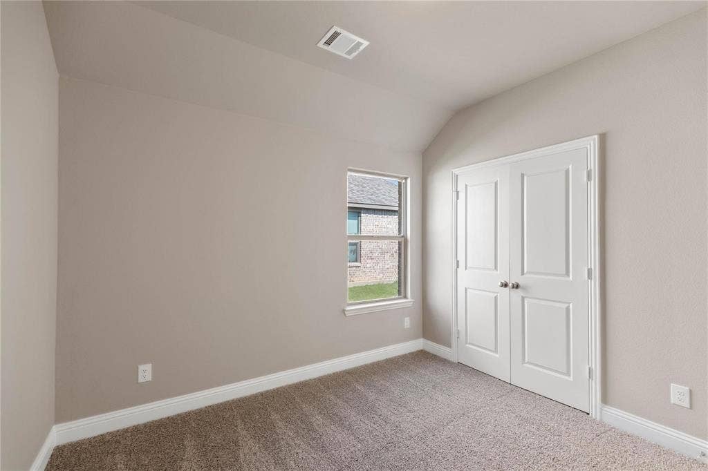 1253 Carinna Drive, Anna, TX 75409 Vaulted ceiling room featuring neutral wall paint, carpeted flooring, a single window, and a white double-door closet