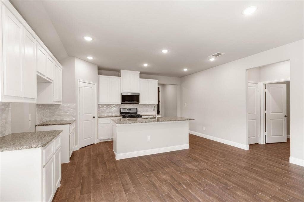 1253 Carinna Drive, Anna, TX 75409 Kitchen featuring white cabinetry, stone-finish countertops, a central island, recessed lighting, and wood-finish flooring