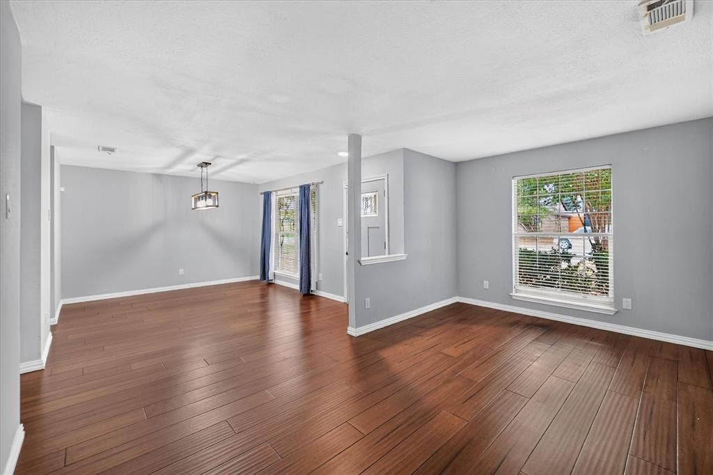Interior space featuring wood-finish flooring, multi-pane windows, and a structured column