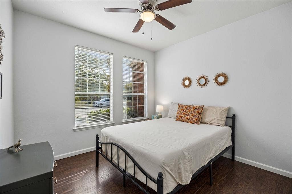 861 Crockett Drive, Lavon, TX 75166 Natural light fills this inviting 1st floor bedroom through two windows overlooking the front of the home. Warm wood-look flooring, neutral walls, and a ceiling fan create a comfortable, versatile space. The room's practical layout and ample natural light make it well suited for a bedroom, guest room, or home office.