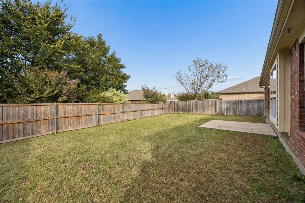 861 Crockett Drive, Lavon, TX 75166 Enjoy the privacy and flexibility of this fenced backyard, featuring an expansive grassy lawn and a concrete patio conveniently located just outside the home. Mature trees and established landscaping beyond the fence add a pleasant natural backdrop, while the open yard provides space for outdoor enjoyment, gardening, or future landscaping enhancements.