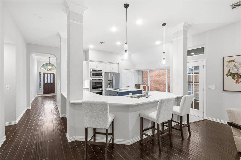4010 Azure Lane, Addison, TX 75001 A sweeping breakfast bar wraps the kitchen in seating space, with sightlines all the way to the front door. Made for gathering.