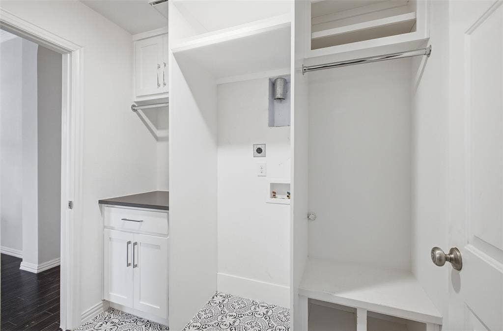 4010 Azure Lane, Addison, TX 75001 A thoughtfully designed utility room with built-in cabinetry, a counter, patterned tile and a built-in drop zone with bench and hanging rod.