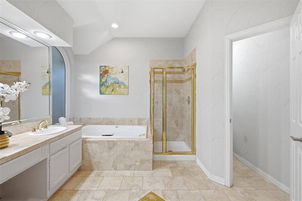 4010 Azure Lane, Addison, TX 75001 Soak, unwind, repeat. The primary bath’s jetted tub and walk-in shower turn every evening into a getaway.