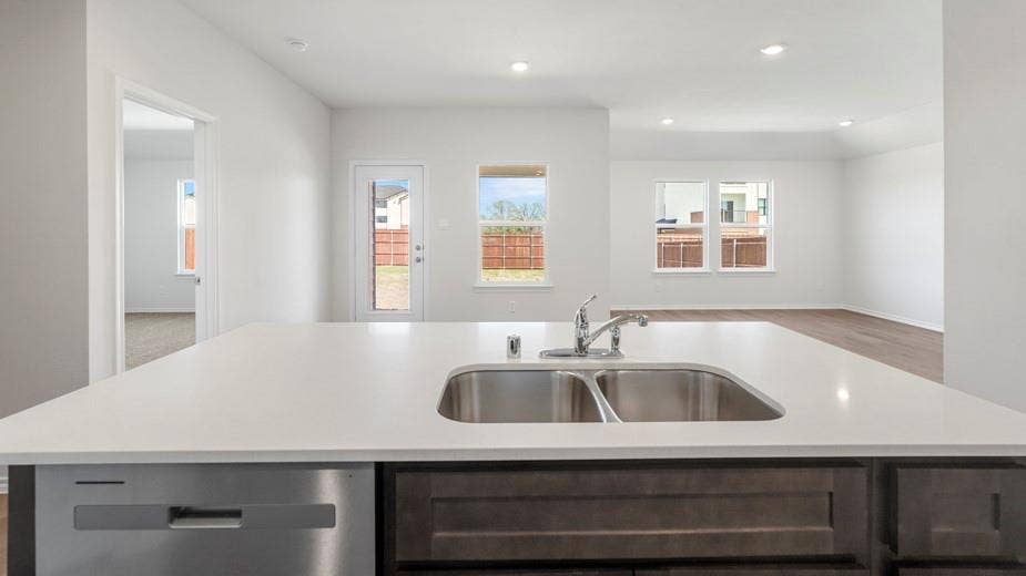 708 Rock Point Road, Josephine, TX 75135 Kitchen island with a dual basin stainless steel sink, stainless steel dishwasher, and dark wood-finish cabinetry