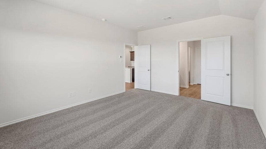 708 Rock Point Road, Josephine, TX 75135 Spacious room featuring neutral carpeting, white walls, and vaulted ceilings