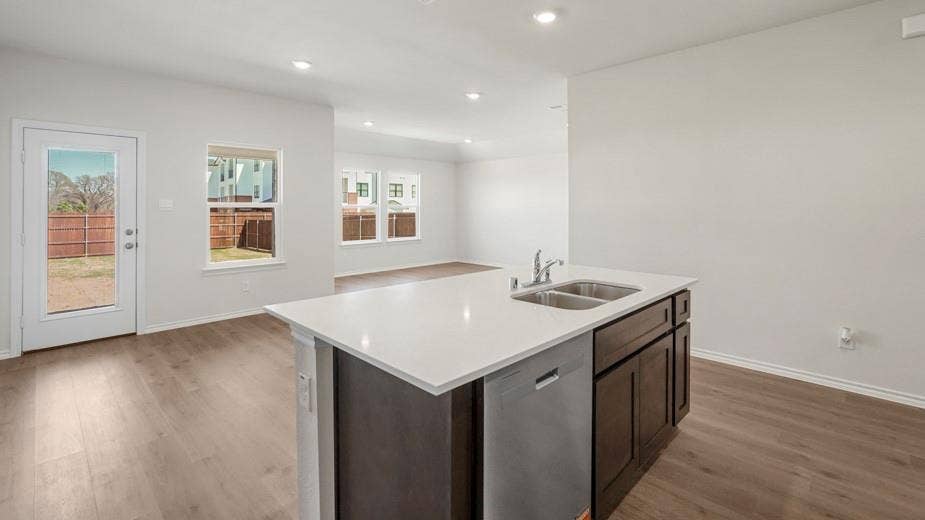 708 Rock Point Road, Josephine, TX 75135 Kitchen island with white countertop, integrated double-basin sink, and dishwasher
