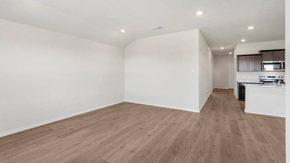 708 Rock Point Road, Josephine, TX 75135 Wood-finish flooring, recessed lighting, white walls, dark wood-finish cabinetry, and stainless steel appliances