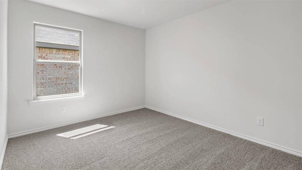 Interior room featuring light gray carpet flooring, white painted walls, and white baseboards