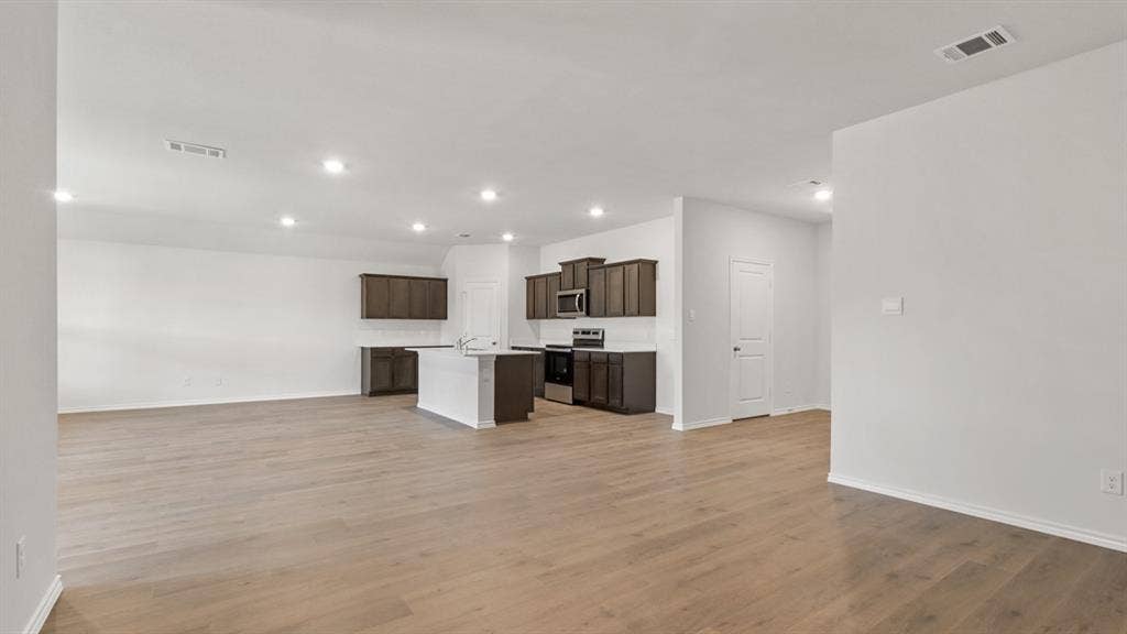 Open-concept living area featuring wood-finish flooring and recessed lighting